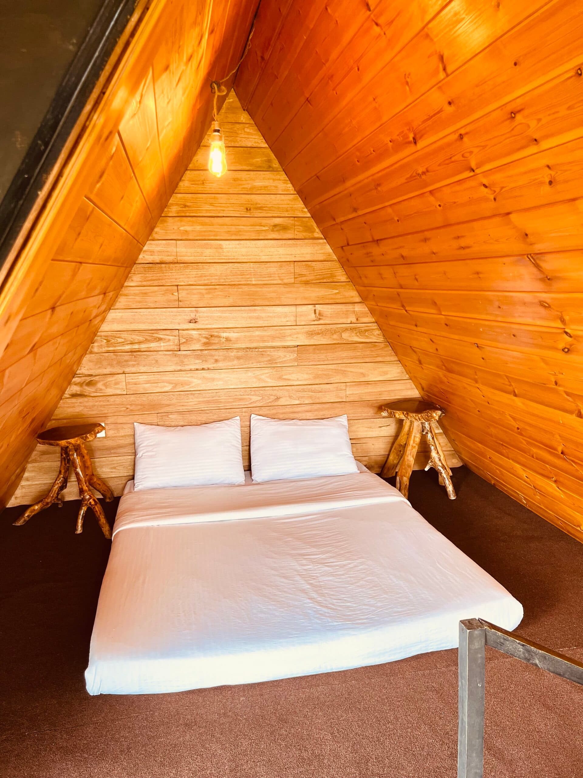 The Vibe cabin — the bed set against the A-frame peak