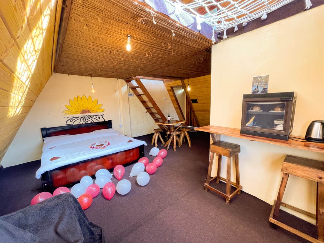 Yellow cabin — the pine-furnished bedroom with a sunflower mural and tea station