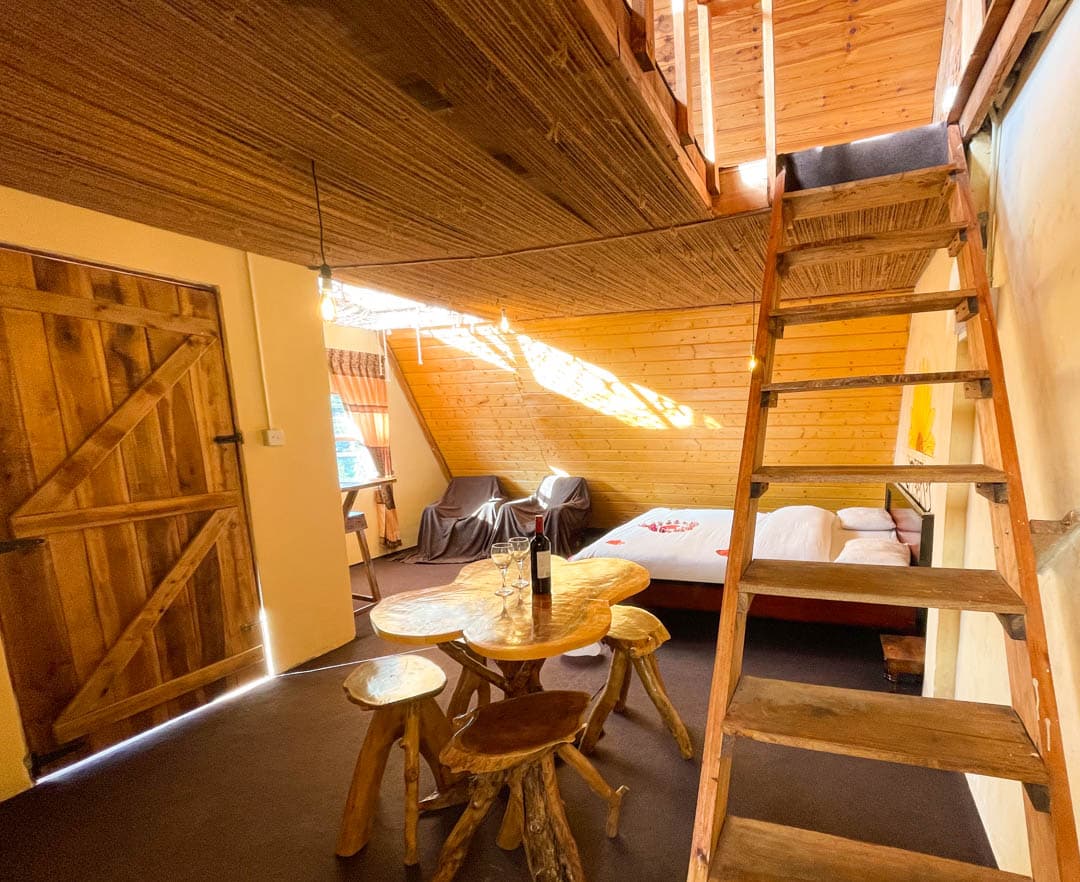 Yellow cabin — ground floor entry with a ladder up to the hammock loft