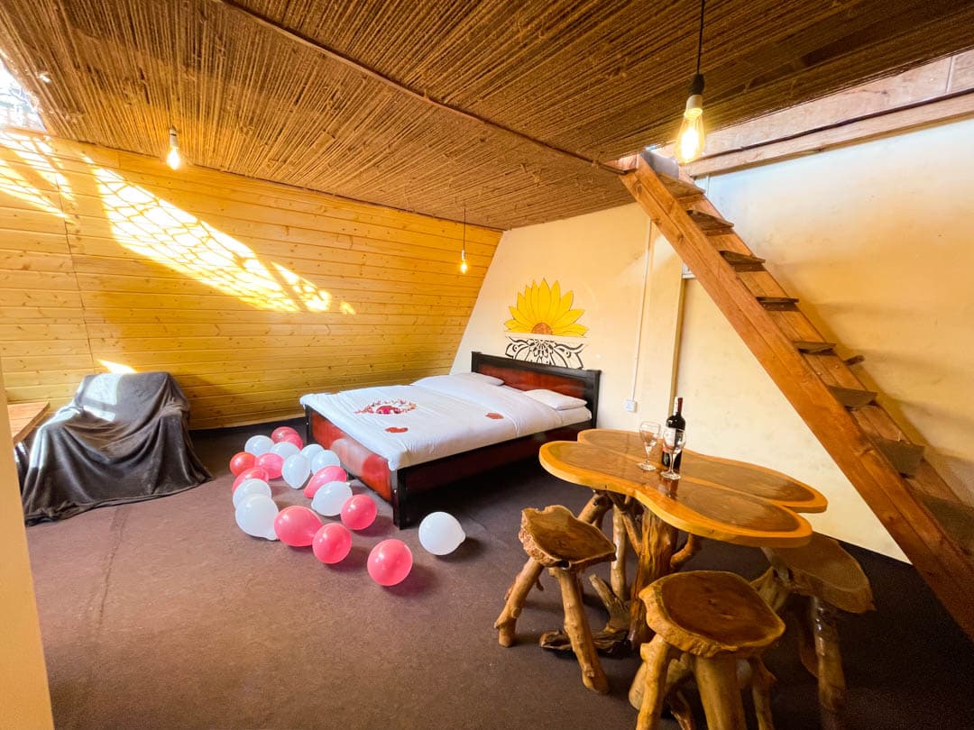 Yellow cabin — the bedroom, with stairs up to the top-floor hammock